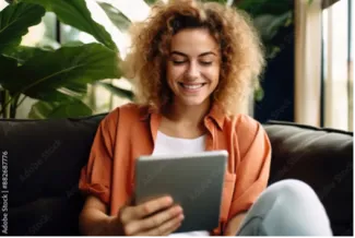 Fröhliche Junge Frau mit Tablet auf Couch